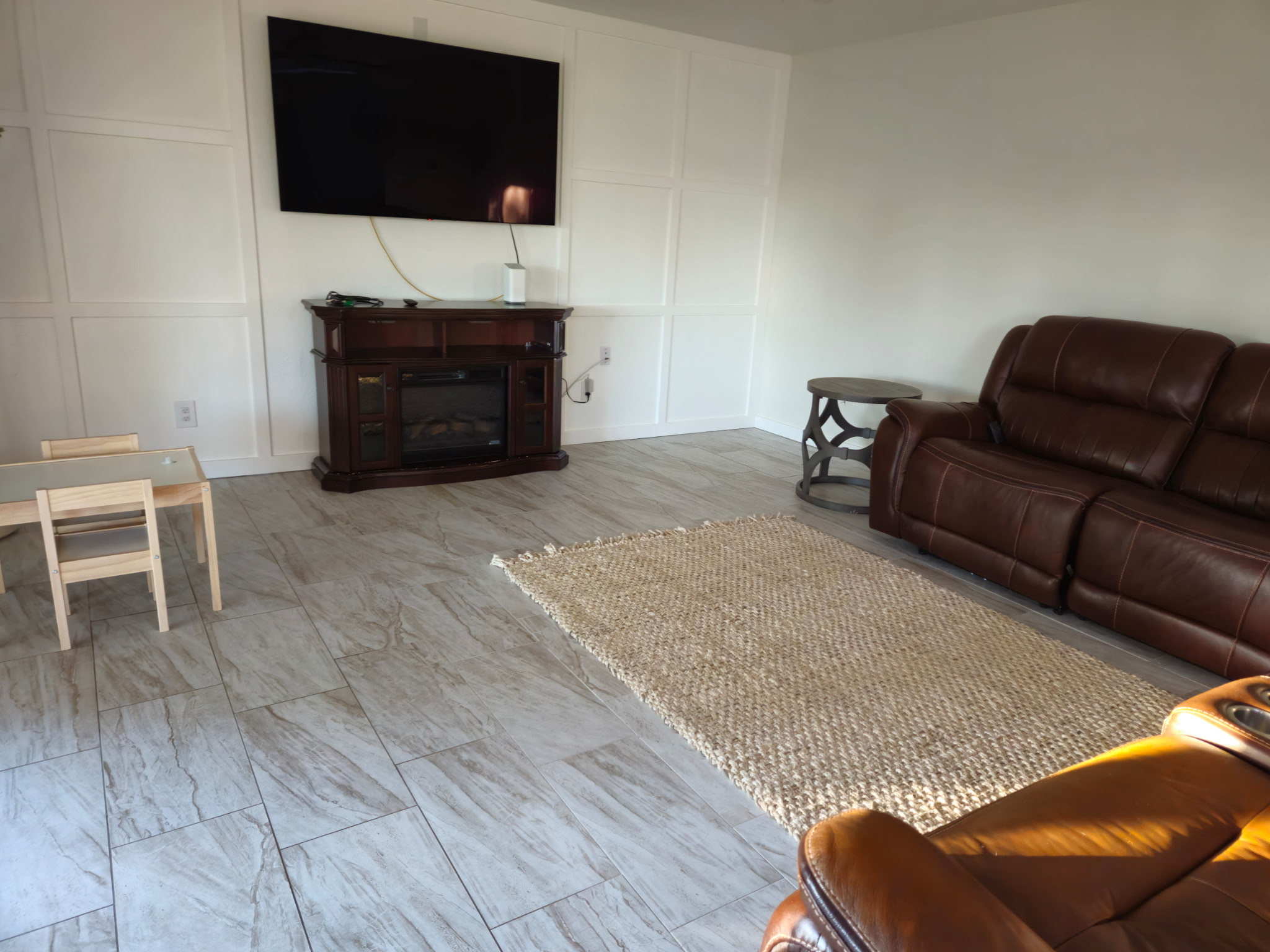 Clean living room with tile floors and leather furniture